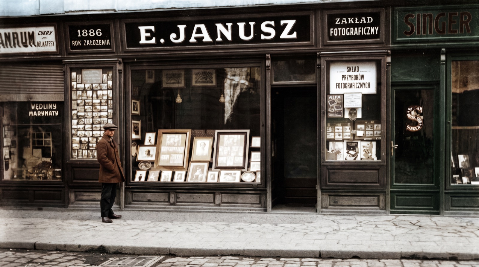 Witryna zakładu fotograficznego E. Janusz w Rzeszowie, z szyldem „1886 rok założenia”, fotografia z dwudziestolecia międzywojennego — koloryzacja AI